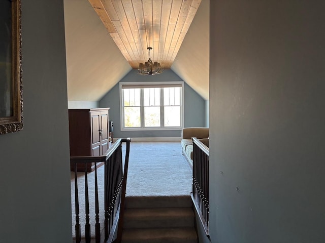 interior space featuring vaulted ceiling, carpet floors, wood ceiling, and a chandelier