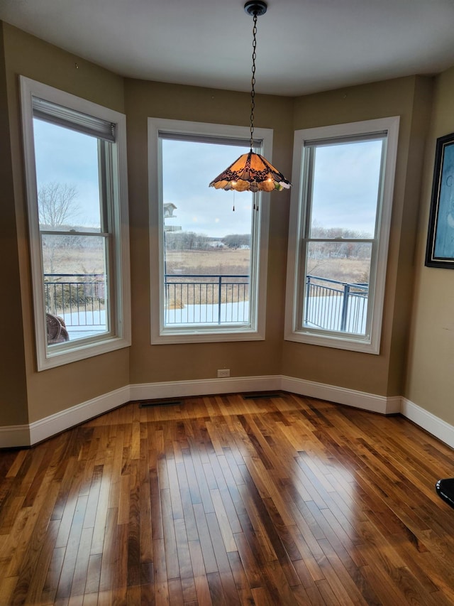 unfurnished dining area featuring dark hardwood / wood-style flooring