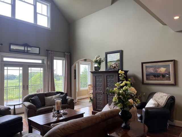 living room featuring hardwood / wood-style floors, high vaulted ceiling, and french doors