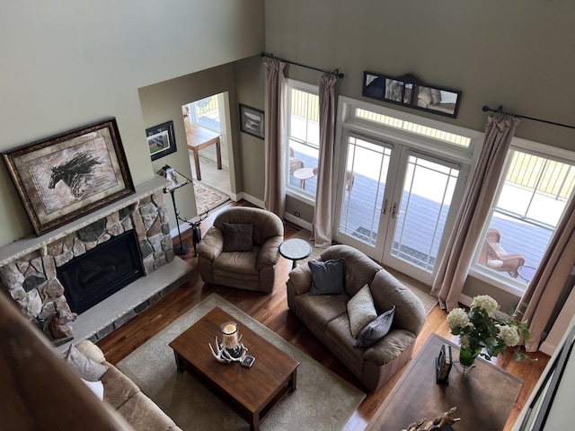 living room featuring hardwood / wood-style floors, a fireplace, and french doors