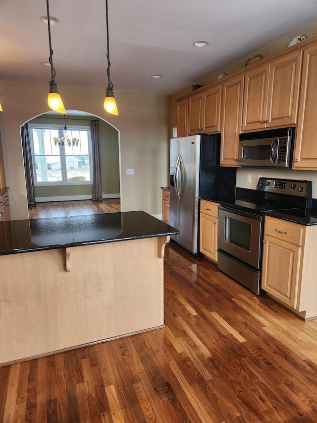 kitchen with arched walkways, a breakfast bar area, stainless steel appliances, dark wood-style floors, and pendant lighting