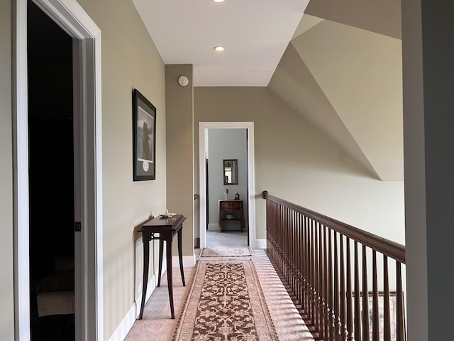 corridor with recessed lighting, light colored carpet, vaulted ceiling, and baseboards