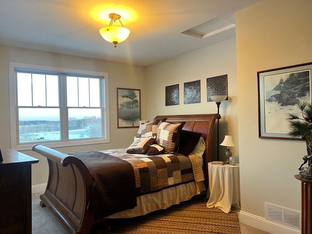 bedroom with baseboards, carpet flooring, visible vents, and attic access