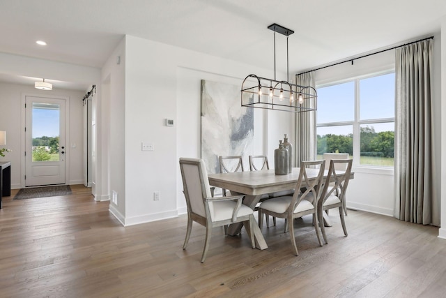 dining area featuring hardwood / wood-style flooring and a barn door