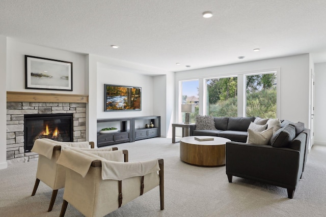 carpeted living room featuring a textured ceiling and a fireplace