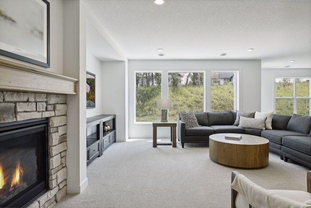 carpeted living room with a textured ceiling and a fireplace