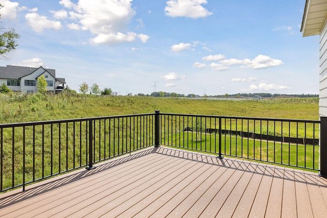 wooden terrace featuring a rural view and a yard