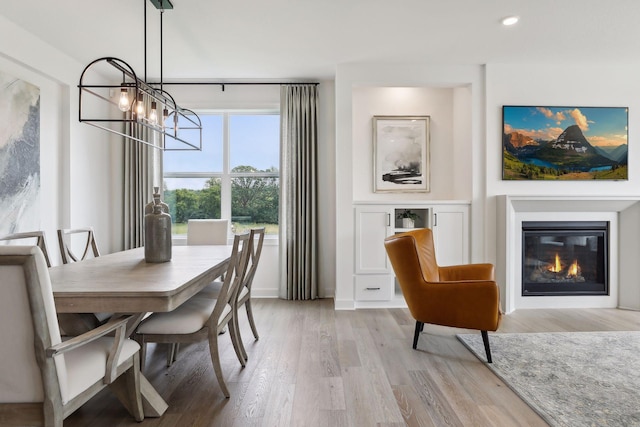 dining space with a notable chandelier and light hardwood / wood-style flooring