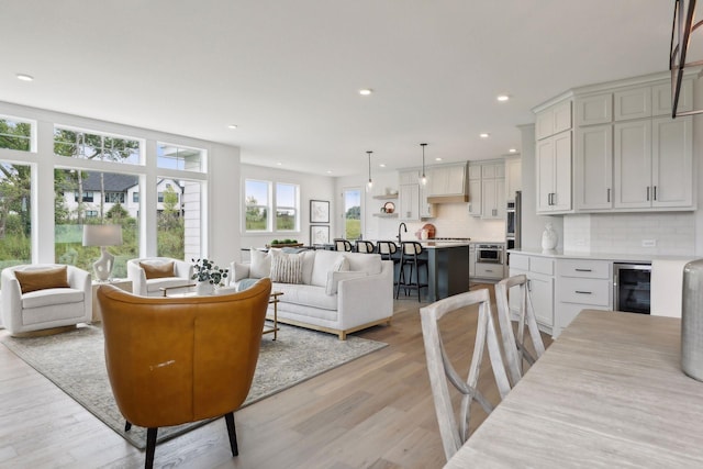 living room featuring wine cooler and light hardwood / wood-style flooring