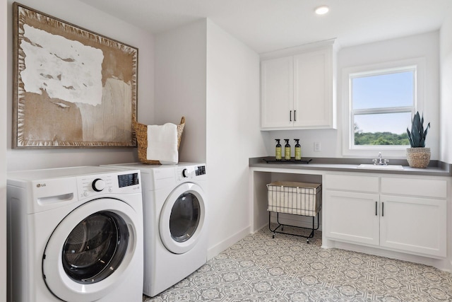 laundry room featuring light tile patterned flooring, cabinets, washer and dryer, and sink