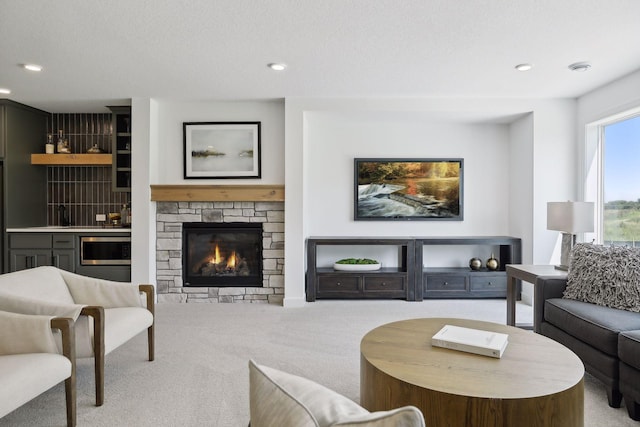 living room with light colored carpet and a stone fireplace