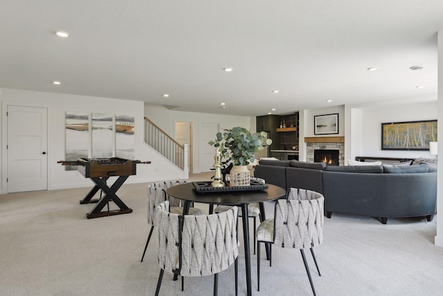 carpeted dining space with a fireplace