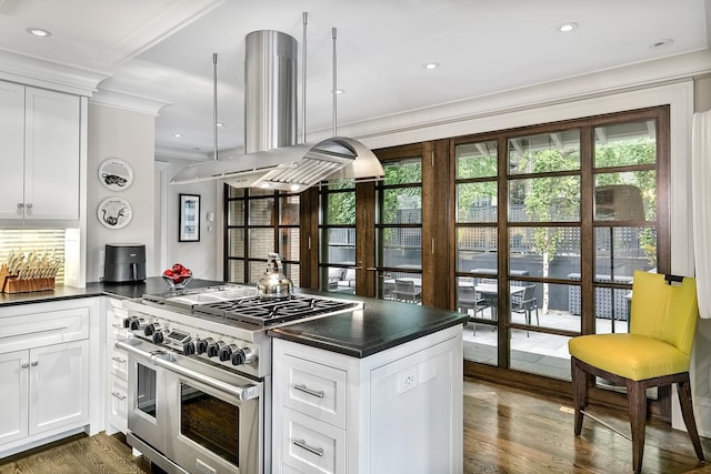 kitchen with plenty of natural light, island range hood, range with two ovens, and white cabinets