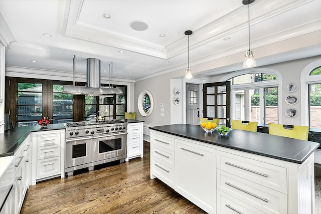 kitchen featuring range with two ovens, pendant lighting, island range hood, and white cabinets