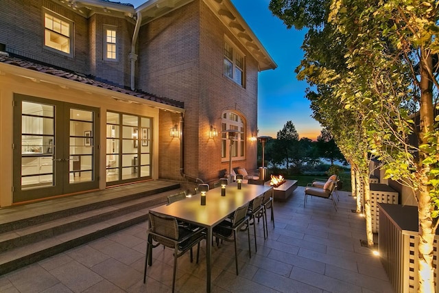 patio terrace at dusk featuring french doors and an outdoor fire pit