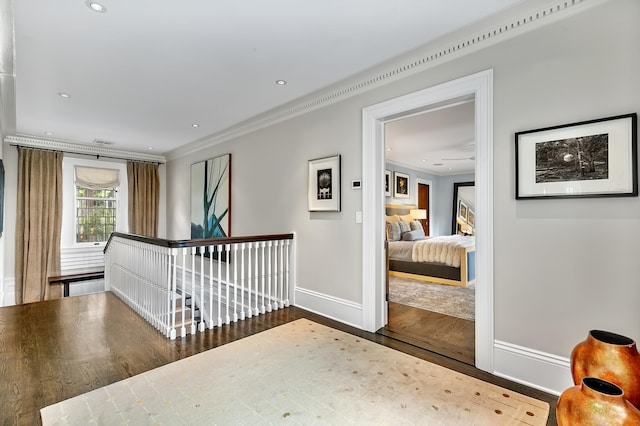 hall with hardwood / wood-style flooring and crown molding