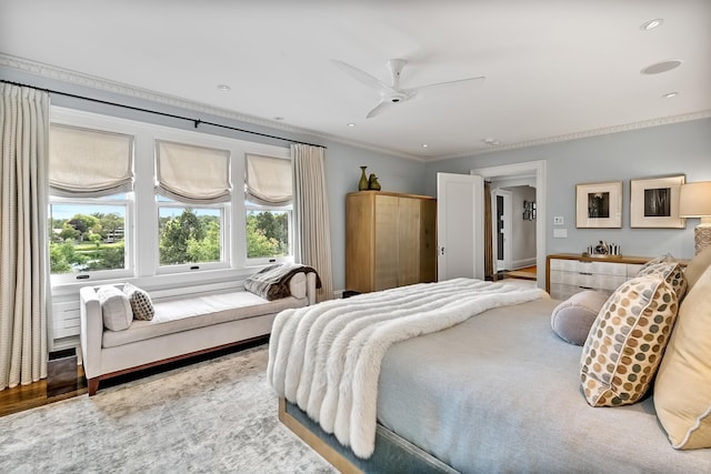 bedroom featuring crown molding, wood-type flooring, and ceiling fan