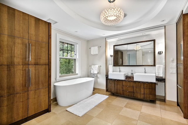 bathroom with vanity, decorative backsplash, a bathtub, and a tray ceiling