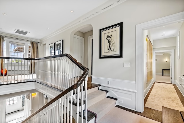 stairs with ornamental molding and wood-type flooring