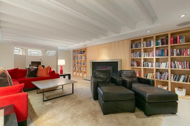 living area featuring beamed ceiling, built in features, and light carpet