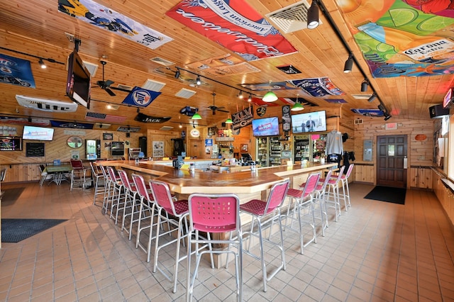 26490 Freedom Valley Dr, Bayview Twp, WI 54891 - bar featuring wood counters, lofted ceiling, wood ceiling, track lighting, and wooden walls