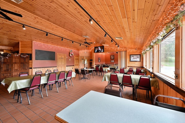 26490 Freedom Valley Dr, Bayview Twp, WI 54891 - tiled dining area with lofted ceiling, track lighting, wooden ceiling, and wood walls