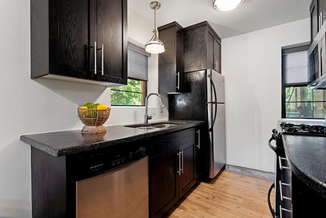 kitchen with dark brown cabinets, light hardwood / wood-style floors, sink, appliances with stainless steel finishes, and decorative light fixtures