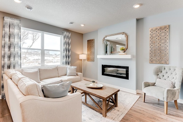 living room with light hardwood / wood-style floors and a textured ceiling