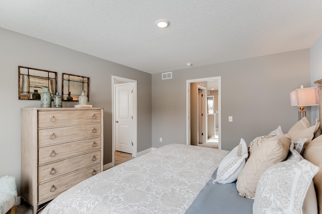 bedroom with light hardwood / wood-style flooring and a textured ceiling