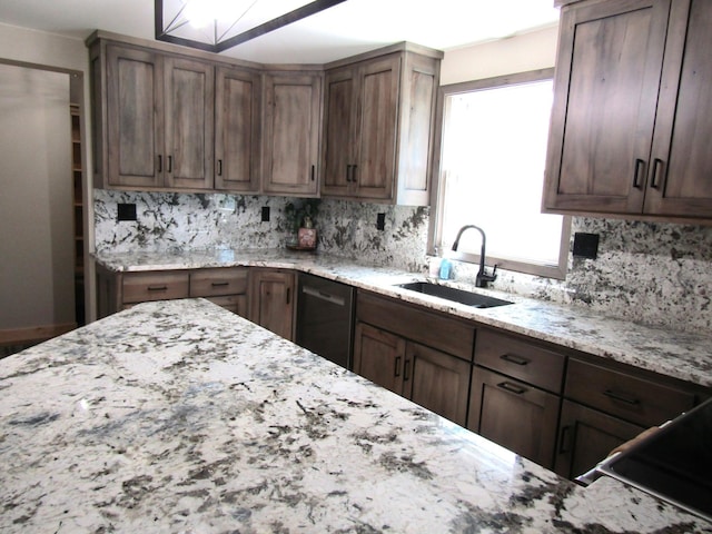 kitchen featuring sink, tasteful backsplash, stainless steel dishwasher, dark brown cabinets, and light stone countertops