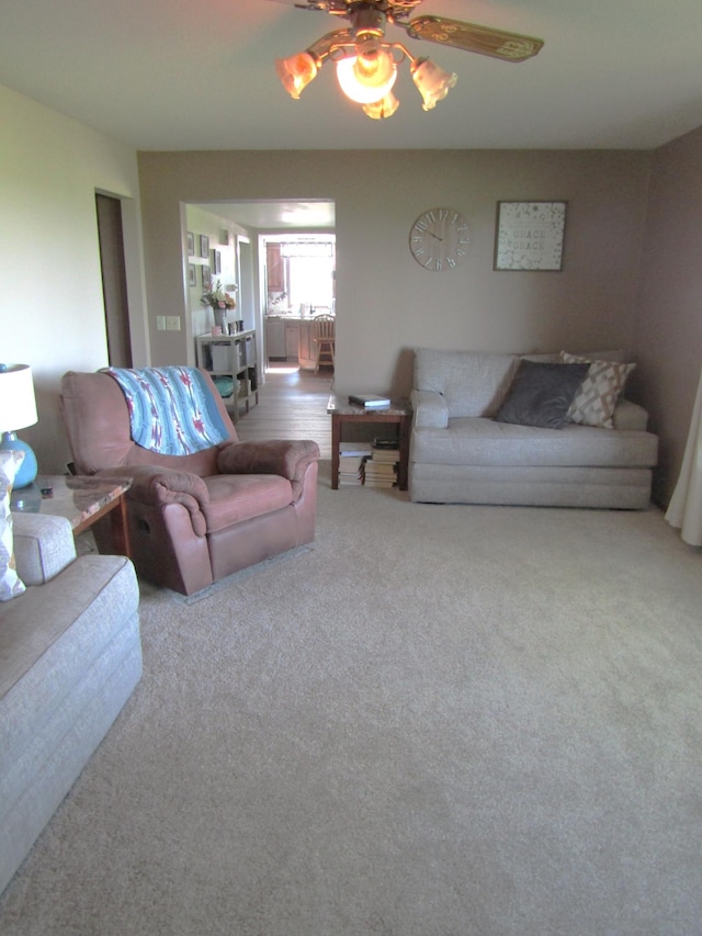 carpeted living room with ceiling fan