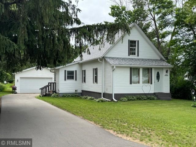 view of front of house featuring a garage, an outbuilding, and a front yard