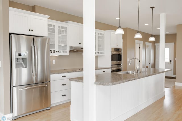 16305 57th St SE, Kindred, ND 58051 - kitchen with appliances with stainless steel finishes, a sink, light wood-style flooring, white cabinets, and under cabinet range hood