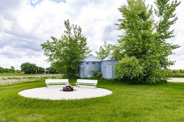 16305 57th St SE, Kindred, ND 58051 - view of green lawn with an outdoor fire pit, a patio area, and an outdoor structure