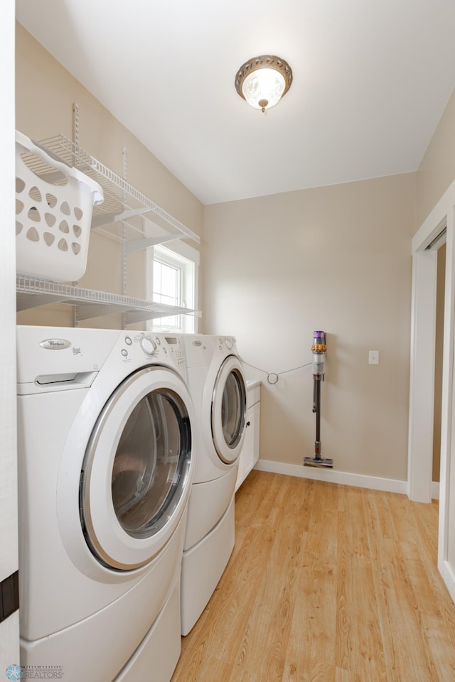 16305 57th St SE, Kindred, ND 58051 - laundry area featuring washer and dryer, light wood-style flooring, cabinet space, and baseboards