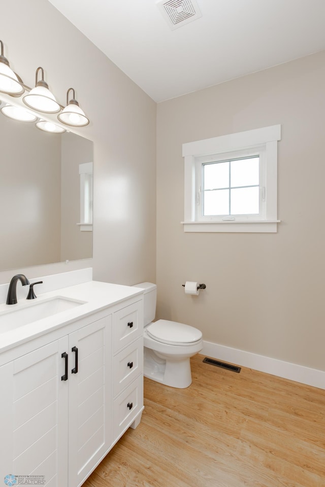 16305 57th St SE, Kindred, ND 58051 - bathroom with vanity, wood finished floors, toilet, and baseboards
