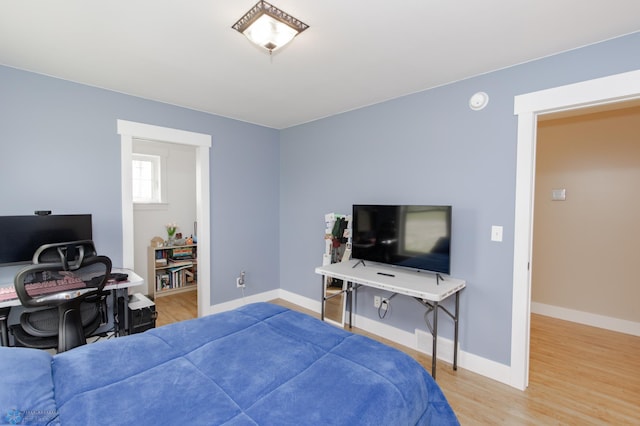16305 57th St SE, Kindred, ND 58051 - bedroom with an office area, wood finished floors, and baseboards