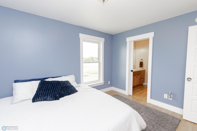 16305 57th St SE, Kindred, ND 58051 - bedroom featuring light wood-type flooring, baseboards, and ensuite bathroom