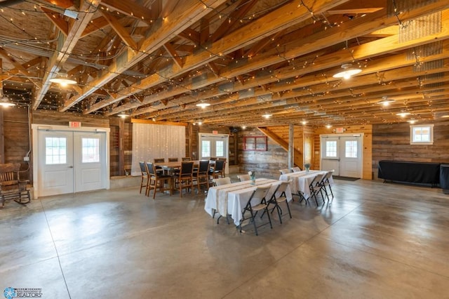 16305 57th St SE, Kindred, ND 58051 - dining space featuring french doors, concrete flooring, and wooden walls