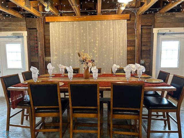 16305 57th St SE, Kindred, ND 58051 - dining room featuring concrete flooring and wood walls