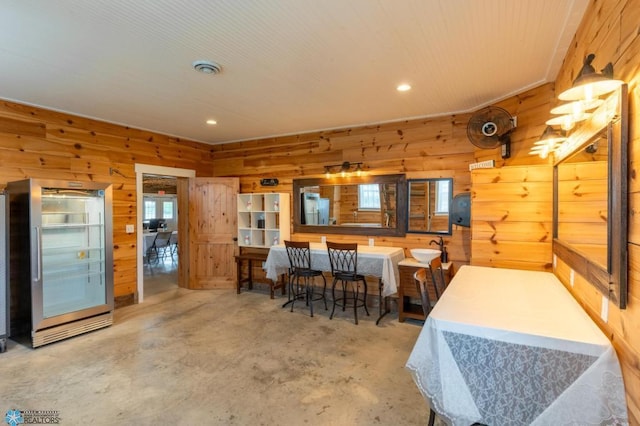16305 57th St SE, Kindred, ND 58051 - dining area with wood walls, concrete flooring, and recessed lighting