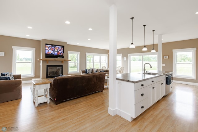 16305 57th St SE, Kindred, ND 58051 - kitchen with a sink, light wood finished floors, open floor plan, a glass covered fireplace, and baseboards