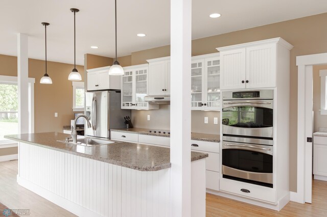 16305 57th St SE, Kindred, ND 58051 - kitchen featuring stainless steel appliances, a sink, white cabinets, light wood finished floors, and recessed lighting