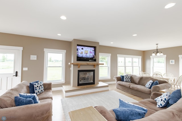 16305 57th St SE, Kindred, ND 58051 - living area with a glass covered fireplace, wood finished floors, recessed lighting, and a chandelier