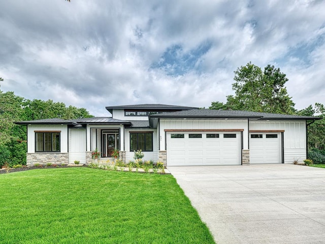 prairie-style home with concrete driveway, a garage, and stone siding