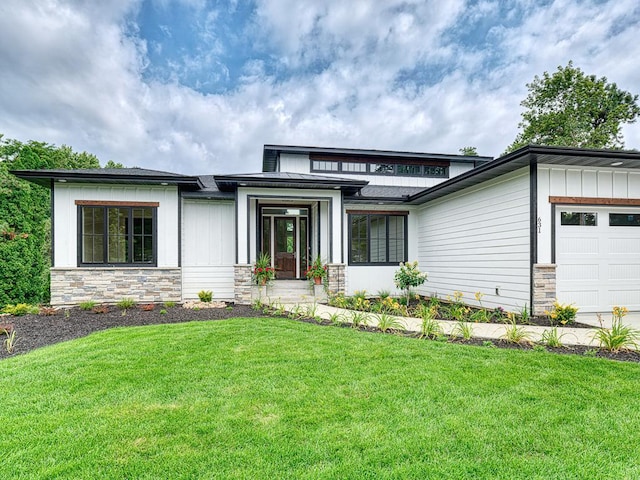 prairie-style home featuring a garage and a front lawn