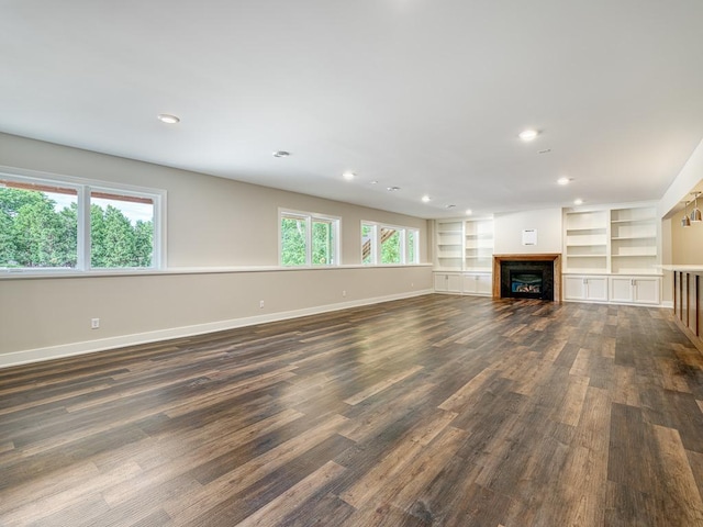 unfurnished living room with built in shelves and dark hardwood / wood-style floors