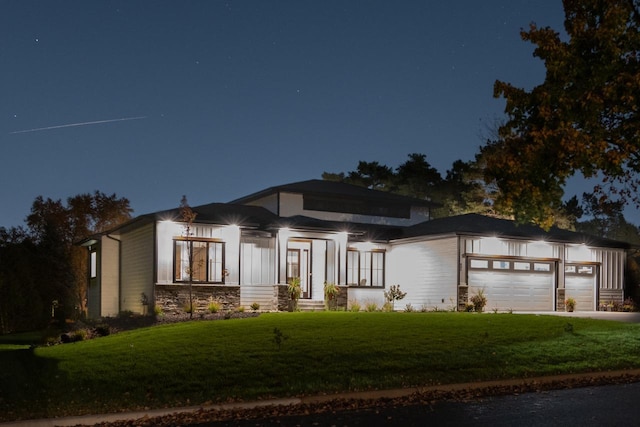 view of front of property featuring a lawn, driveway, and an attached garage