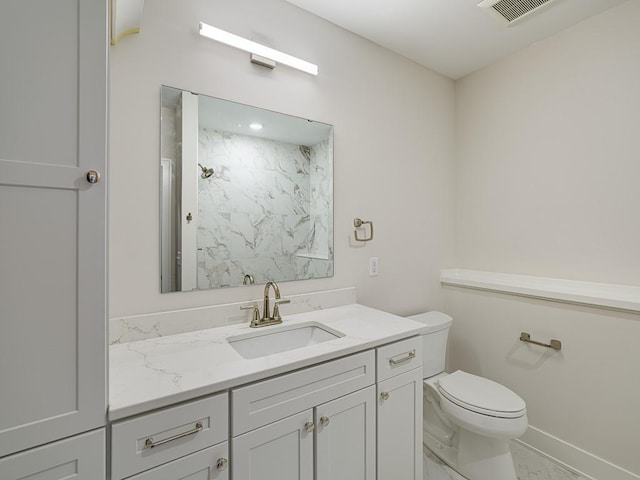 bathroom featuring toilet, a shower, vanity, visible vents, and baseboards