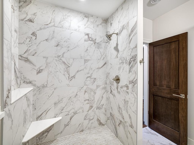 full bath featuring tiled shower and marble finish floor